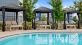 a pool with cabanas with lounge chairs