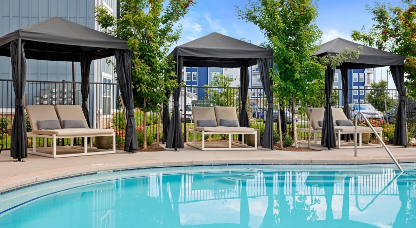 Resort style pool a pool with cabanas with lounge chairs