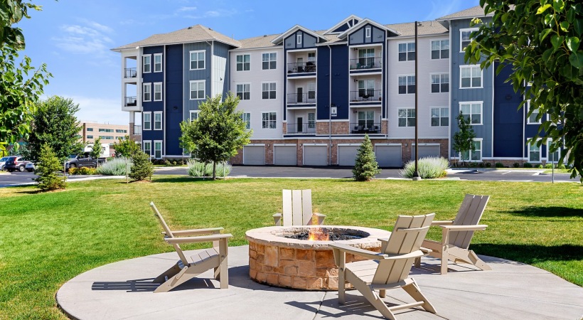 The essence of exceptional living a firepit with chairs and a building in the backgrounnd