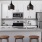 a kitchen with white cabinets and a fridge and an island with seating