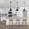 a kitchen with white cabinets a fridge and an island with seating